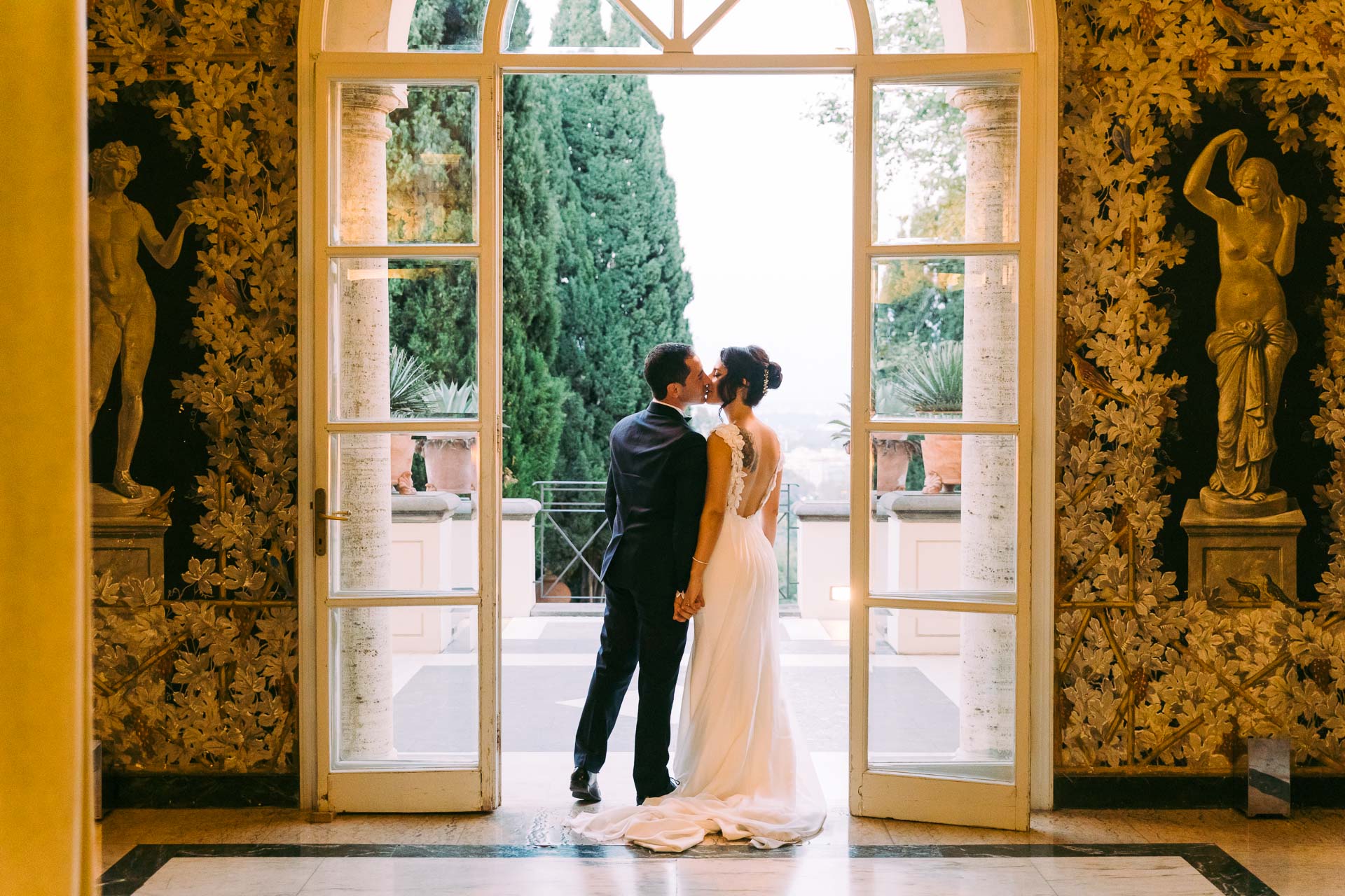Sara and Giuseppe framed by the architecture of Villa Miani in Rome.