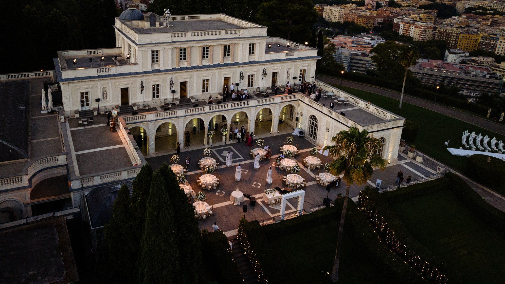 An illuminated wedding reception on terraces above Rome